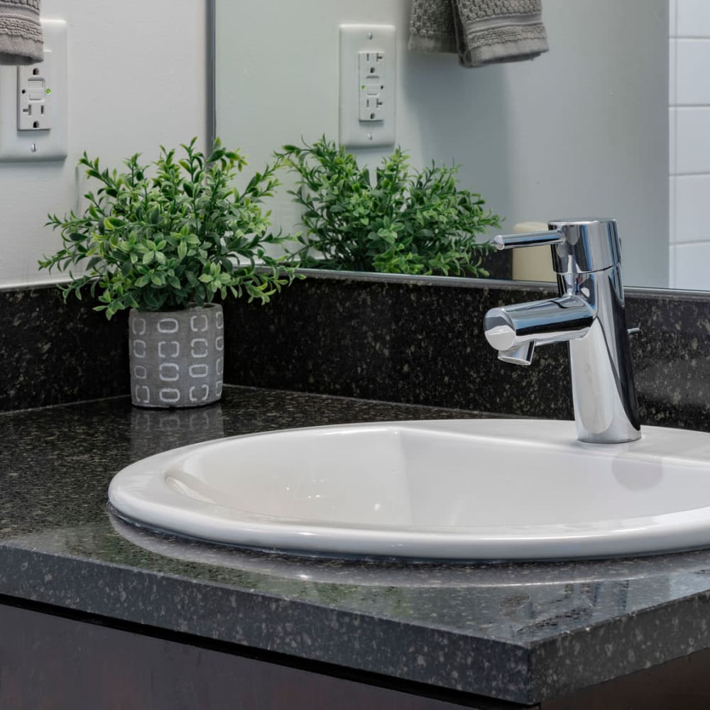 Granite countertop and new faucet fixtures in a model apartment's bathroom at CitiTower in Orlando, Florida