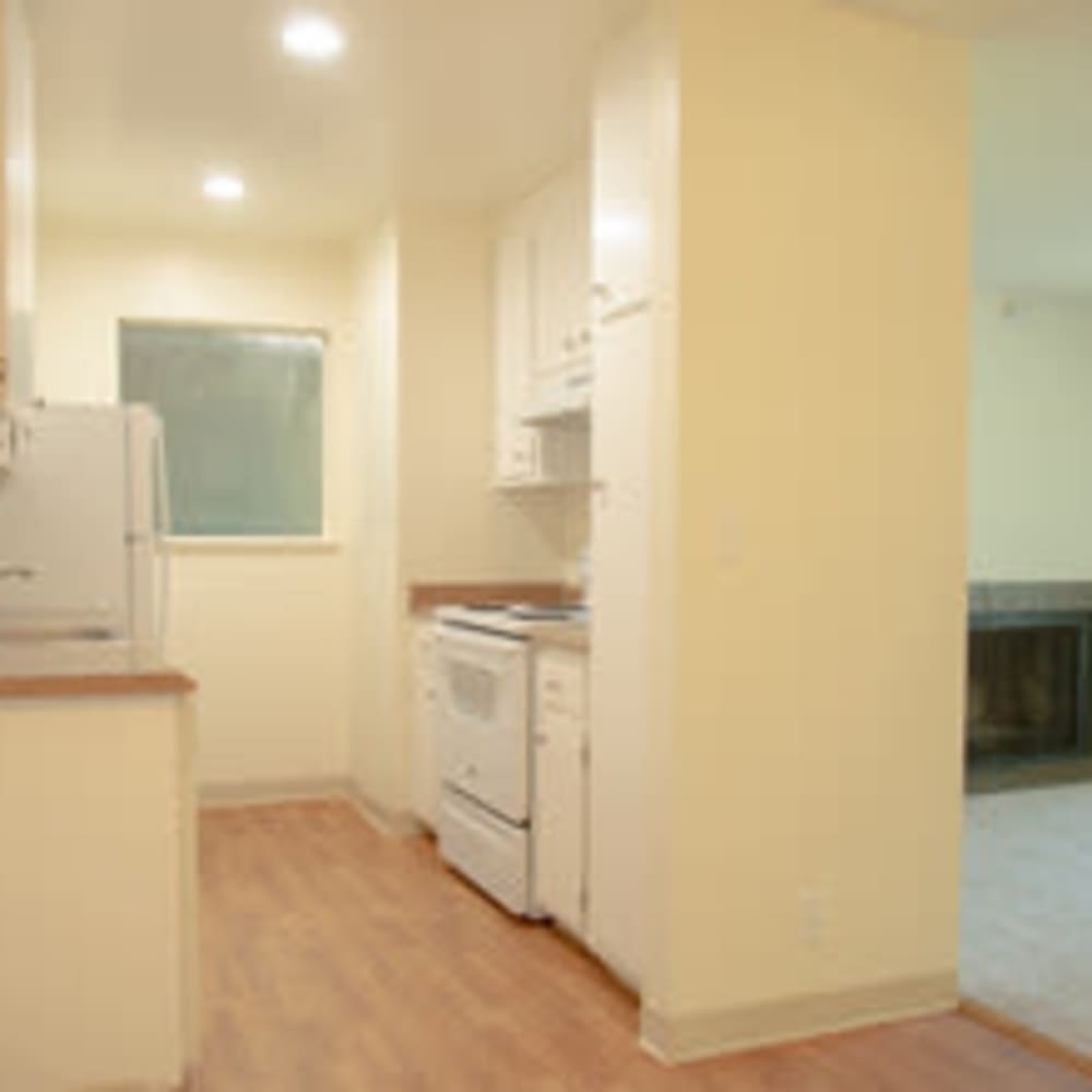 Hardwood-style flooring and white appliances in a model home's kitchen at Mission Rock at Novato in Novato, California