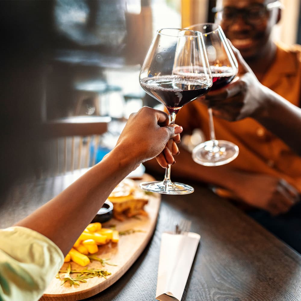 Resident couple at a downtown restaurant raising a toast to their decision to move to Mission Rock at Marin in San Rafael, California