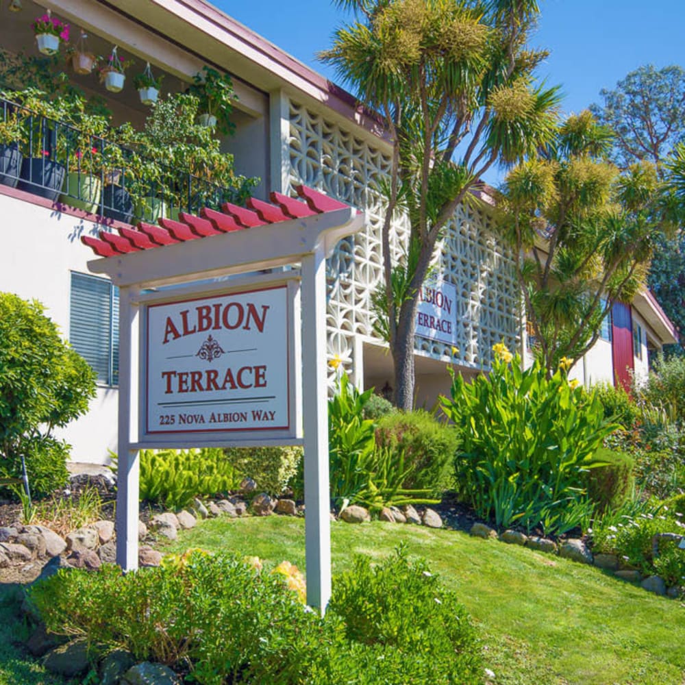 Community sign and lush landscaping welcoming residents and guests to Mission Rock at San Rafael in San Rafael, California