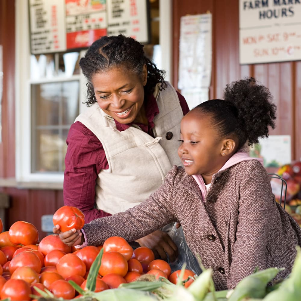 Resident and her granddaughter shopping for fresh produce at a market near our Village Green Senior community at Mission Rock at Sonoma in Sonoma, California