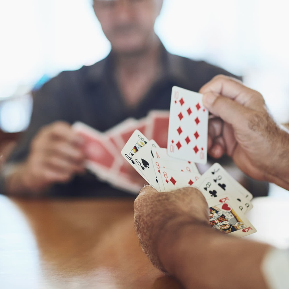 Residents playing cards at a senior living community by Cascade Senior Living Services