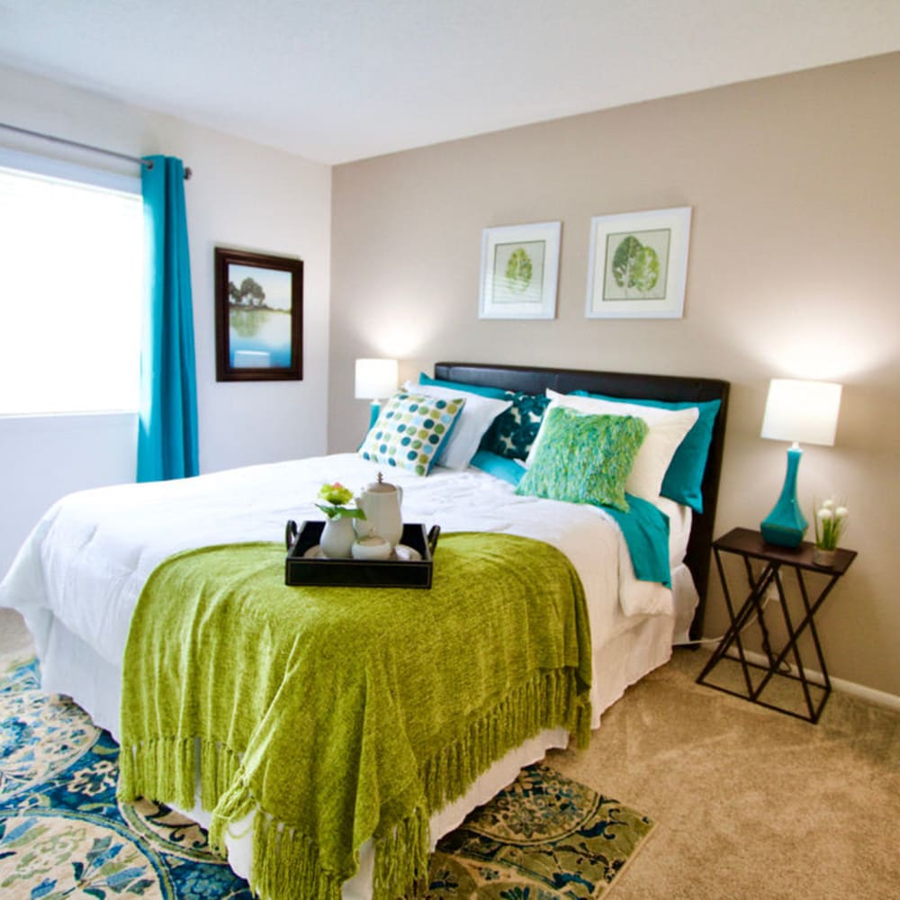 a well-lit bedroom with green and blue details at Greenbrier Woods Apartments in Chesapeake, Virginia