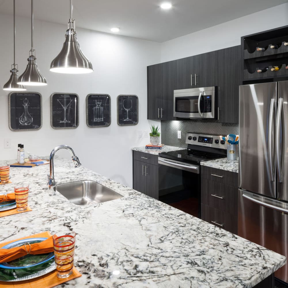 Modern kitchen with nice granite countertops at Alma Hub 121 in McKinney, Texas