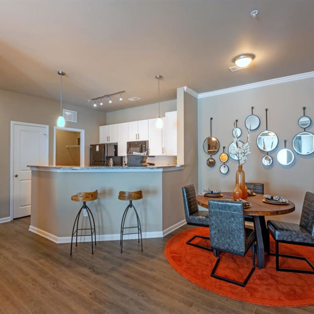 A dining room table set and bar seating at a kitchen island at Lullwater at Blair Stone in Tallahassee, Florida