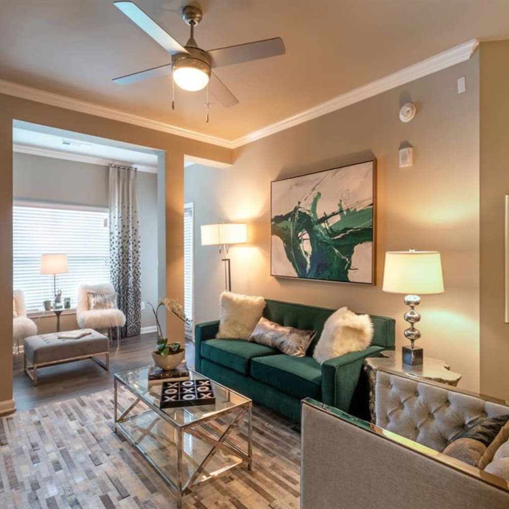 An inviting, furnished apartment living room with couches, a coffee table and a rug at Lullwater at Blair Stone in Tallahassee, Florida