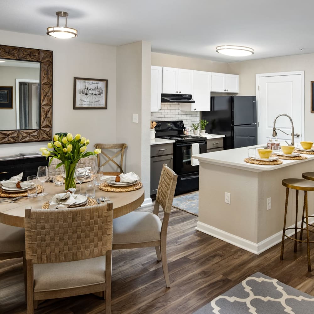 A decorated dining room table and apartment kitchen at Heritage at Riverstone in Canton, Georgia
