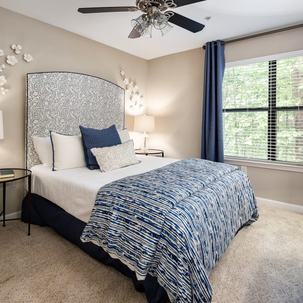Plush carpeting and a ceiling fan in a furnished apartment bedroom at Heritage at Riverstone in Canton, Georgia