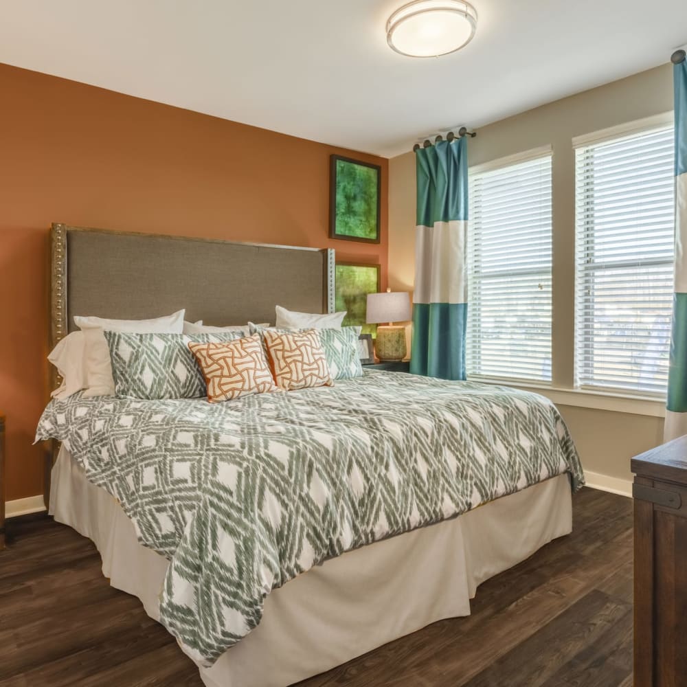 A large bed with throw pillows in the main bedroom of an apartment at Liberty Mill in Germantown, Maryland