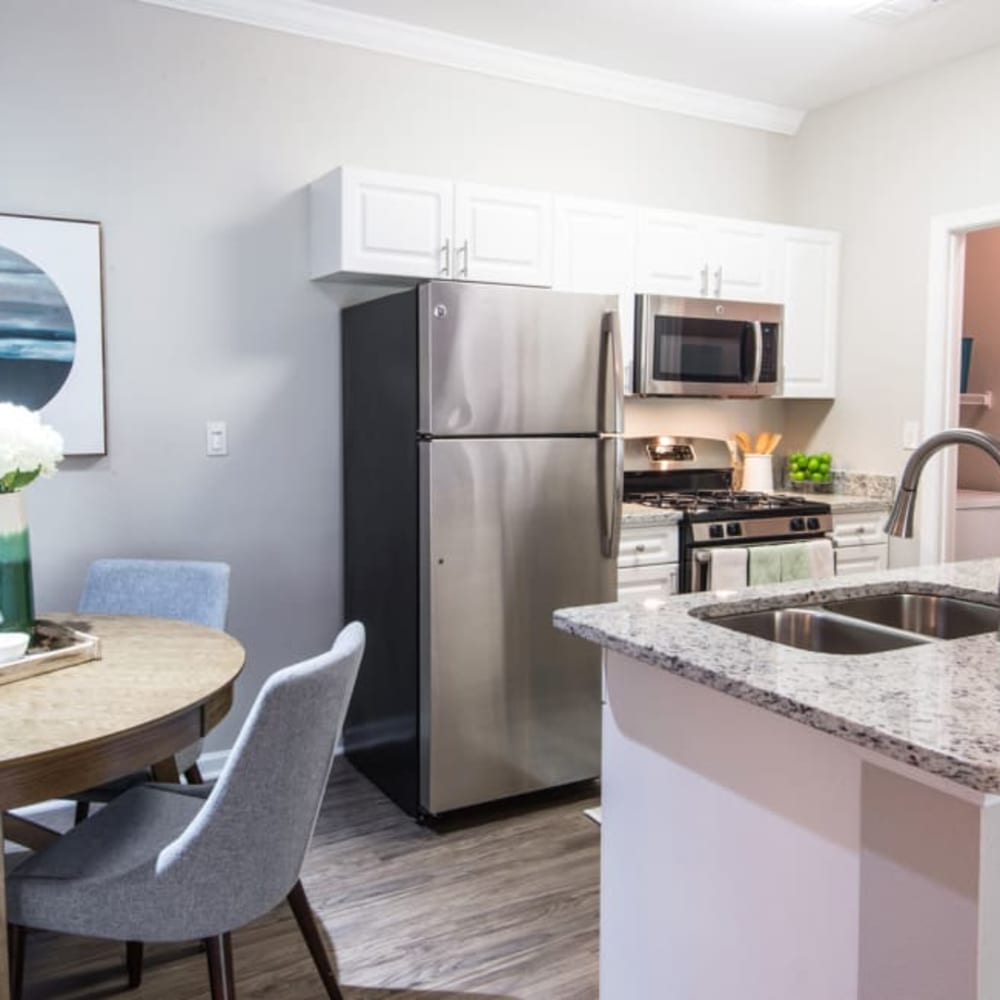 An apartment kitchen and dining room at Riverstone at Owings Mills in Owings Mills, Maryland