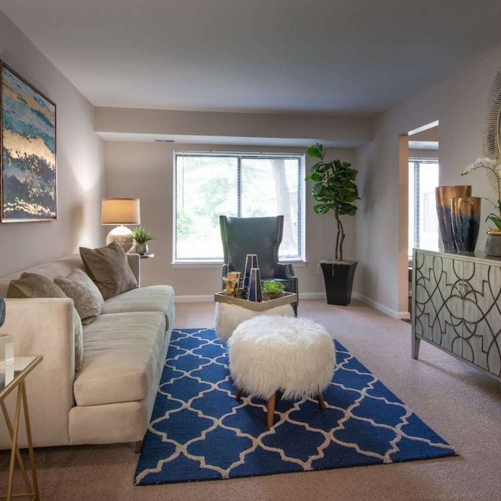 A furnished apartment living room with a beautiful painting at The Elms at Old Mill in Millersville, Maryland