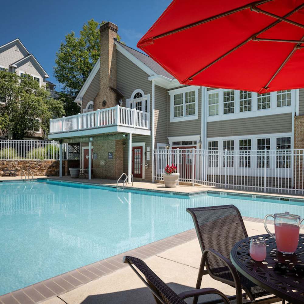 Swimming pool with community building view at The Elms at Oakton in Fairfax, Virginia