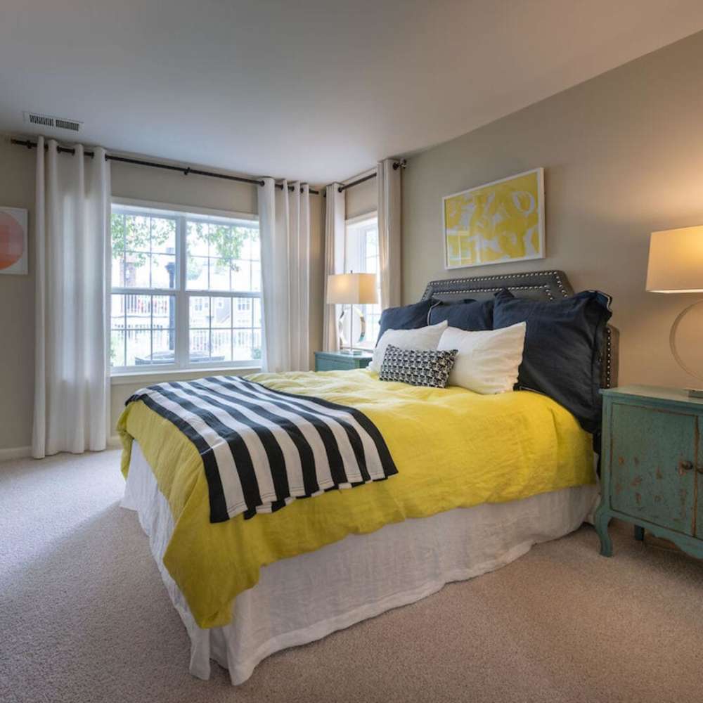 Spacious bedroom with large comfortable bed and window sunlight at The Elms at Oakton in Fairfax, Virginia