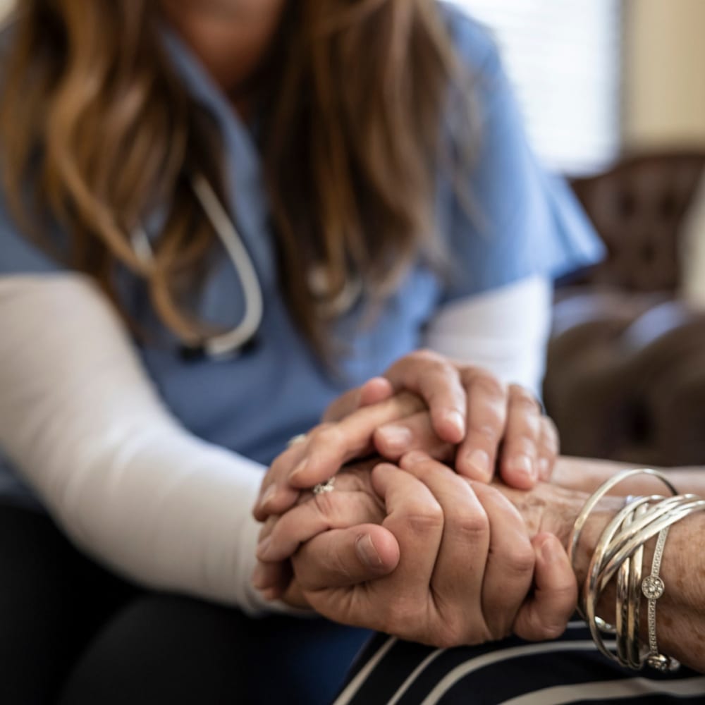 Caretaker holding a residents hand at Regency Redmond Rehabilitation and Nursing Center in Redmond, Oregon