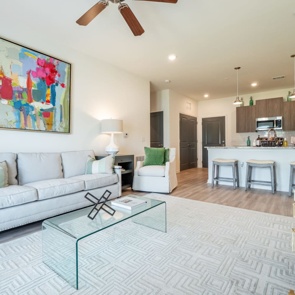 A furnished apartment living room with the kitchen in the background at The Station at Brighton in Grovetown, Georgia