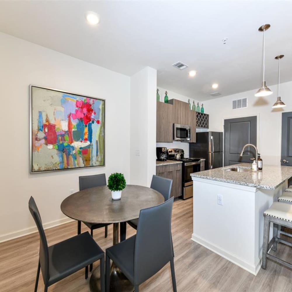 A dining room table next to the kitchen in an apartment at The Station at Brighton in Grovetown, Georgia