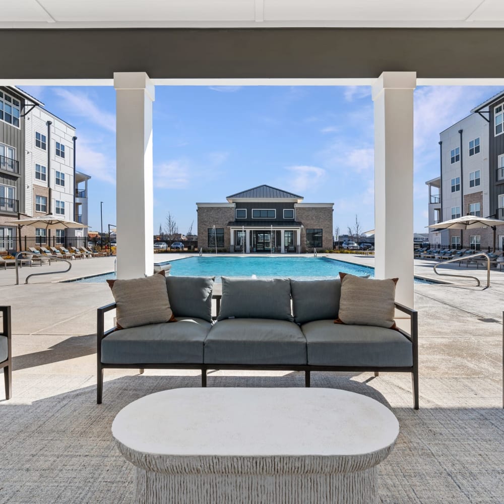 Covered outdoor seating by the community pool at The Station at Clift Farm in Madison, Alabama