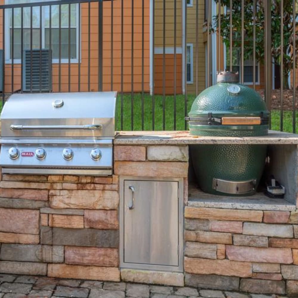 An outdoor grilling station and trash can near the swimming pool at Evergreens at Mahan in Tallahassee, Florida