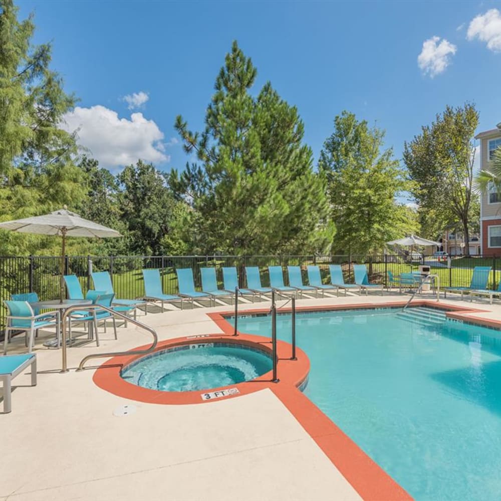 The community swimming pool and spa with seating around it at Evergreens at Mahan in Tallahassee, Florida