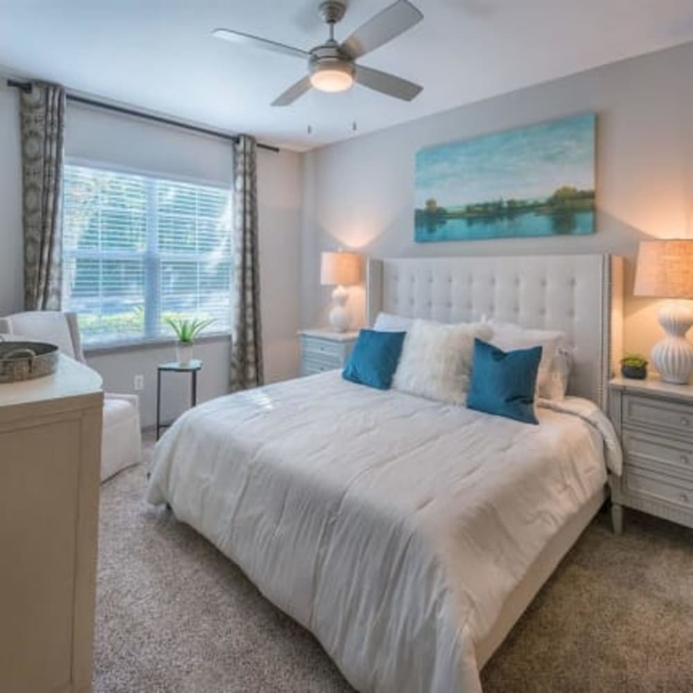 A king sized bed in a main bedroom of an apartment at Evergreens at Mahan in Tallahassee, Florida