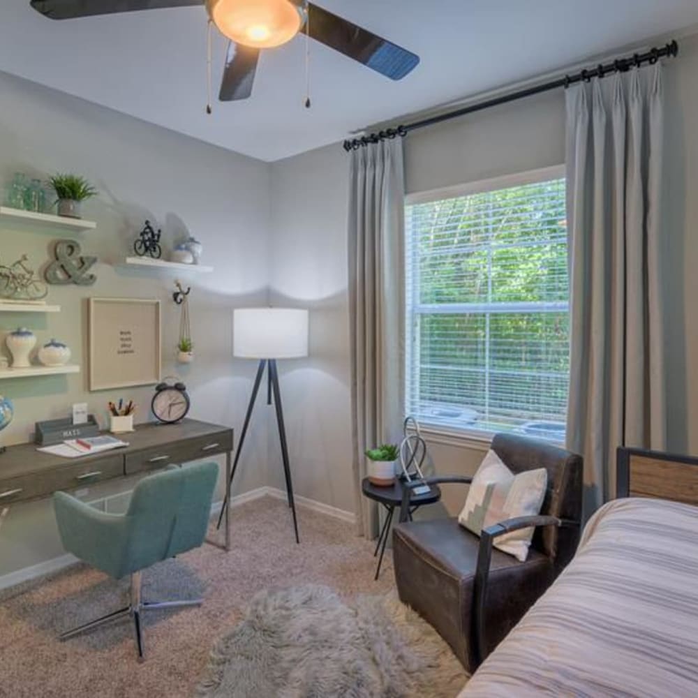 A desk, office chair and comfortable lounge seating in a home office at Evergreens at Mahan in Tallahassee, Florida