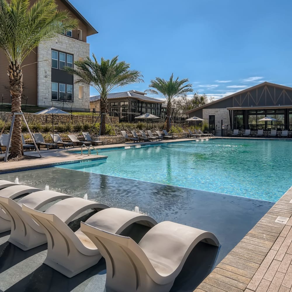 Lounge seating in the community swimming pool at Cypress McKinney Falls in Austin, Texas