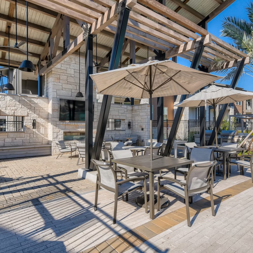 Covered outdoor seating by the swimming pool at Cypress McKinney Falls in Austin, Texas