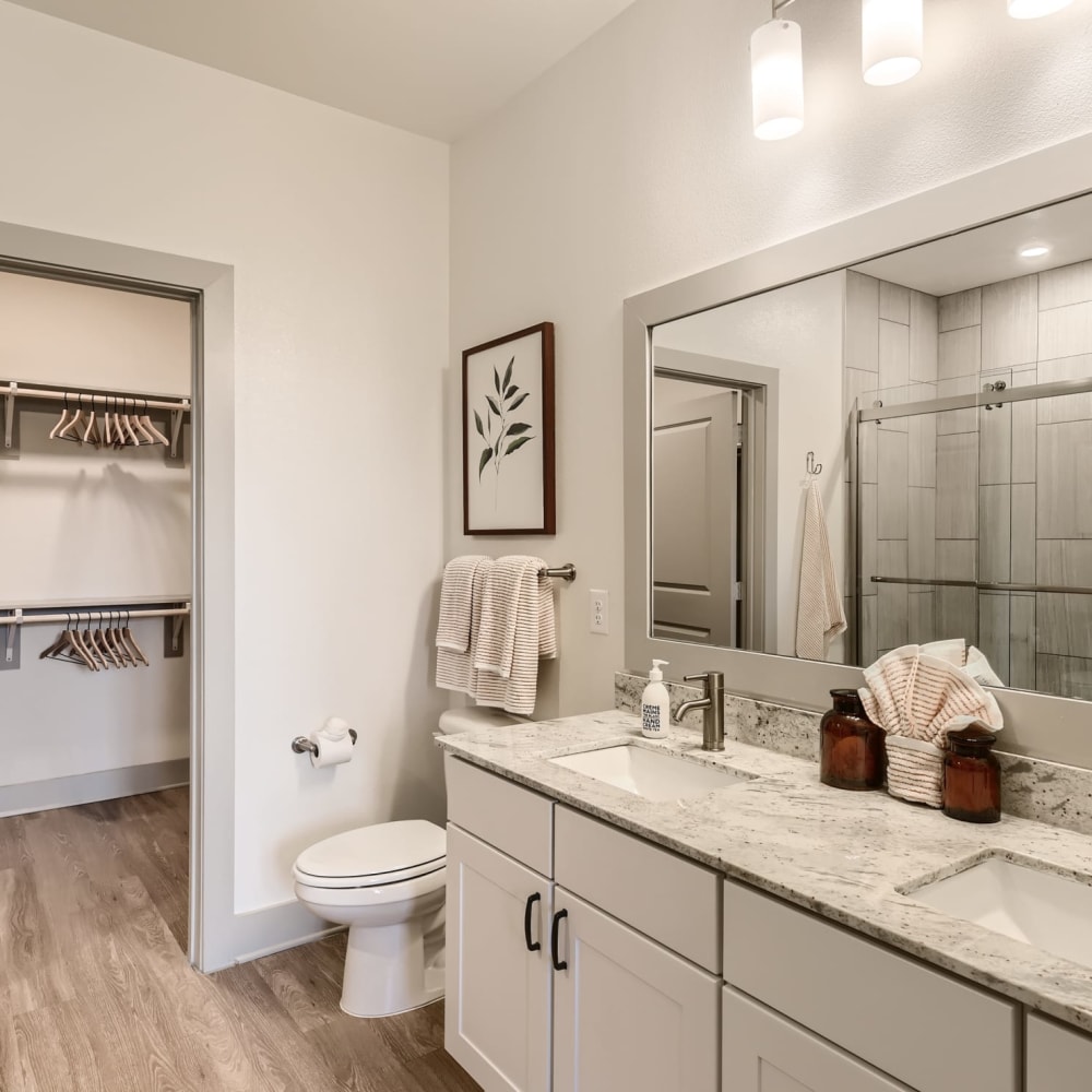 A double sink countertop and attached closet in an apartment at Cypress McKinney Falls in Austin, Texas