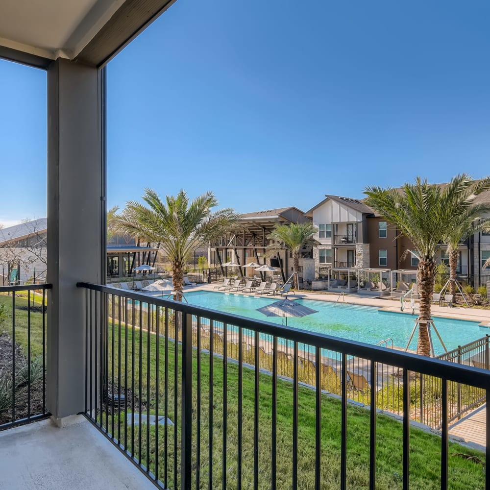 View of the community swimming pool from an apartment balcony at Cypress McKinney Falls in Austin, Texas