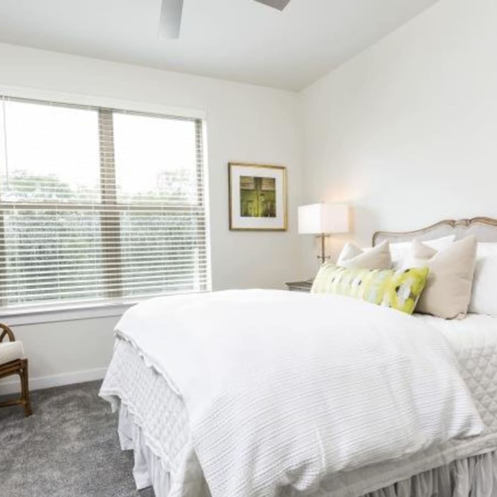 A large, well-made bed in an apartment bedroom at Retreat at Fairhope Village in Fairhope, Alabama