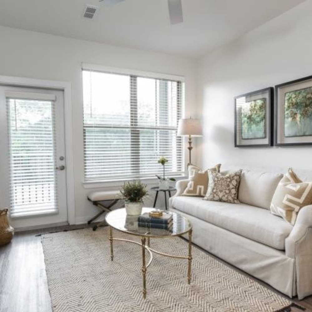 A furnished living room with a door to the balcony at Retreat at Fairhope Village in Fairhope, Alabama