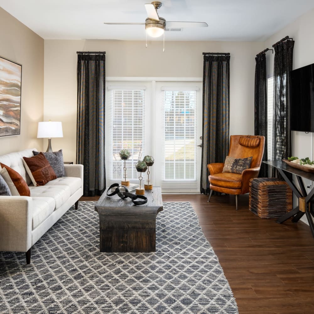A furnished apartment living room with wood flooring at The Alexandria in Madison, Alabama