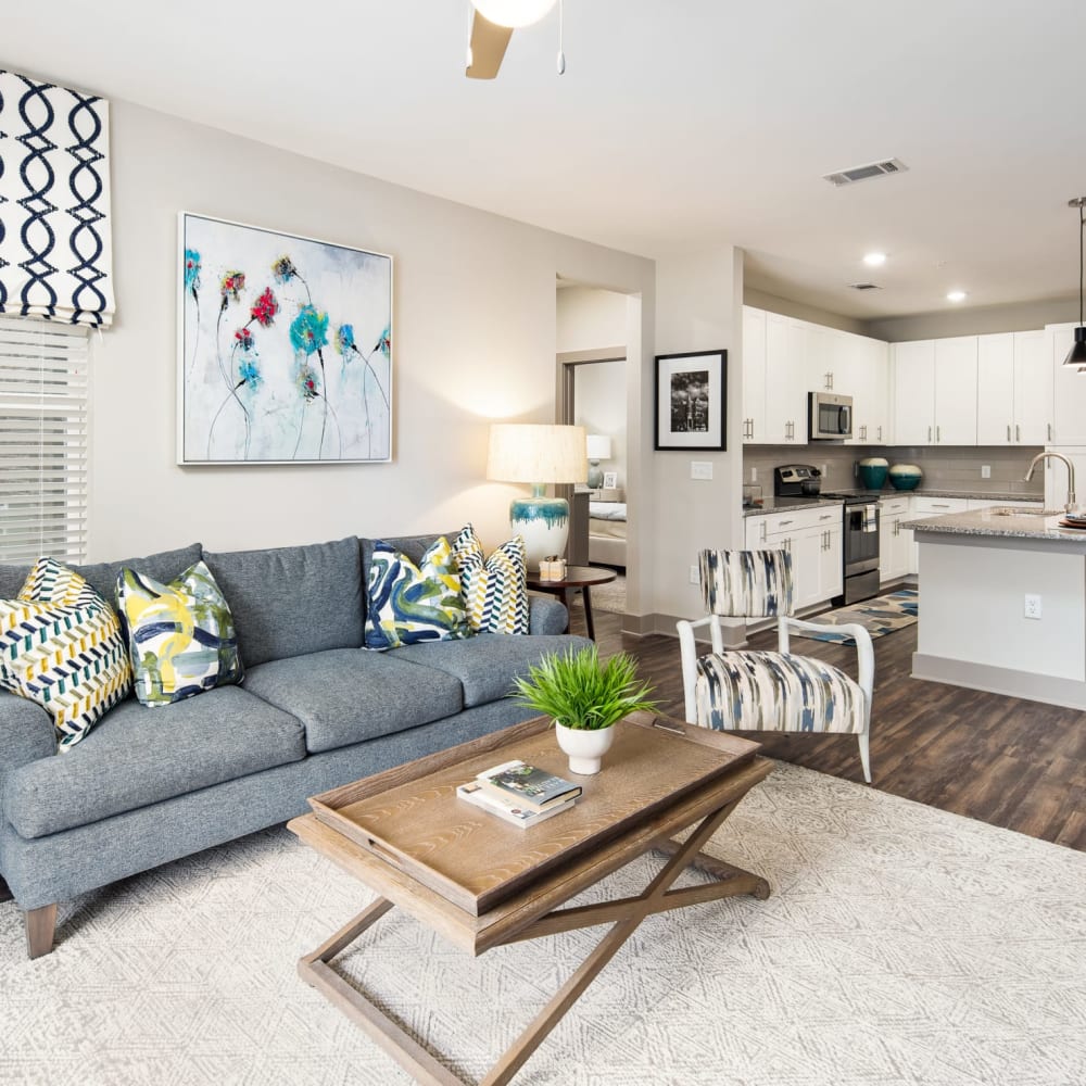 A furnished apartment living room with the kitchen in the background at The Highland in Augusta, Georgia