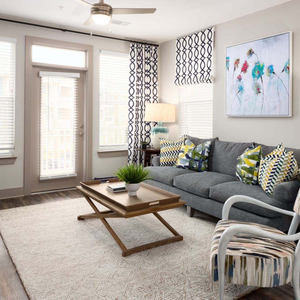 A furnished apartment living room with a door to the patio at The Highland in Augusta, Georgia