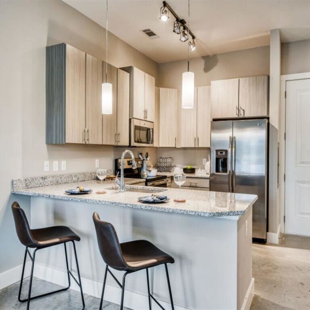 Seating at a bar island in an apartment kitchen at The Lively Indigo Run in Ladson, South Carolina