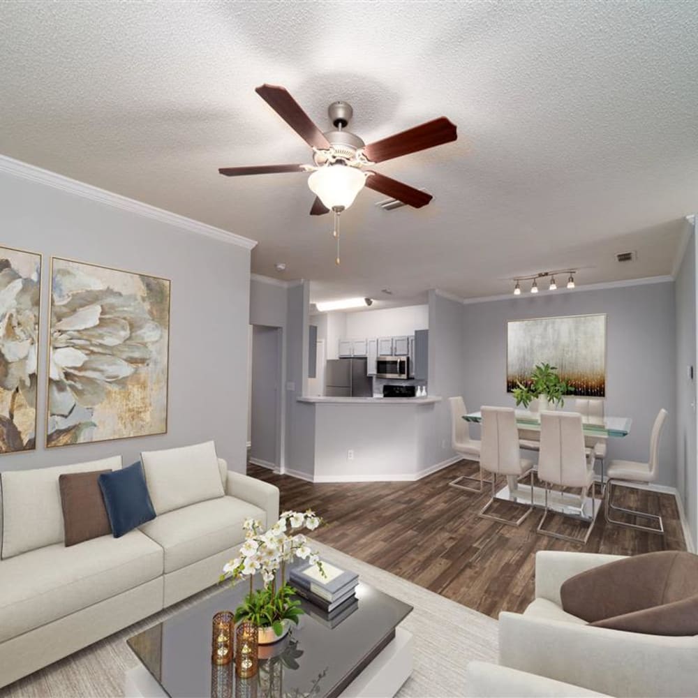A furnished apartment living room and dining room with wood flooring at Astoria in Mobile, Alabama