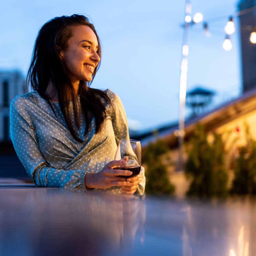 A resident enjoying a glass of wine at her favorite spot near Avemore Apartment Homes in Charlottesville, Virginia