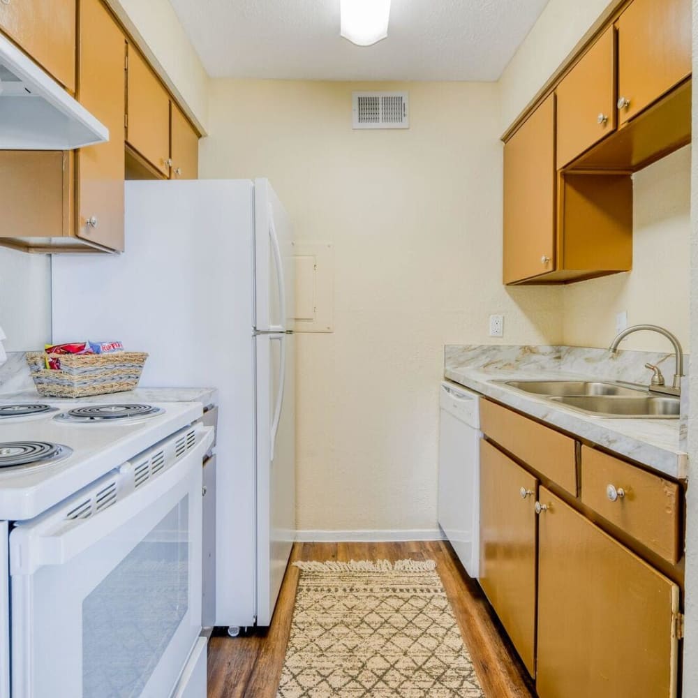 Apartment kitchen with white appliances at Villas del Tesoro in Dallas, Texas