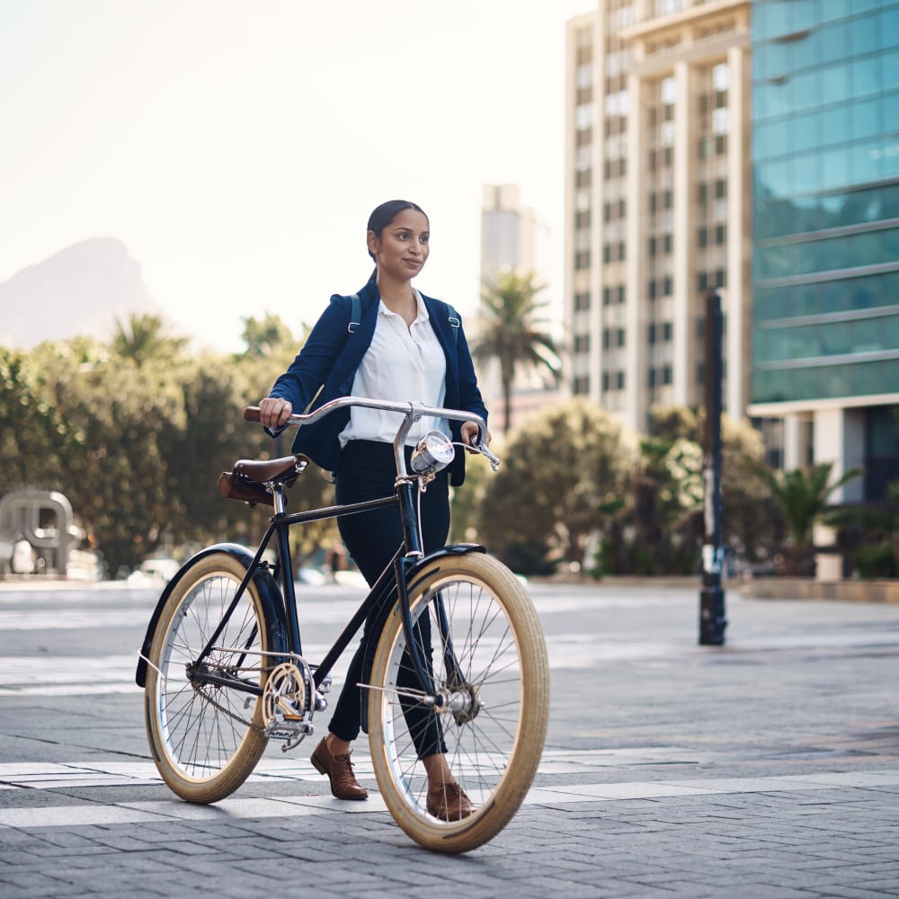 A woman walking her bicycle across a downtown plaza near Theatre Lofts in Birmingham, Alabama