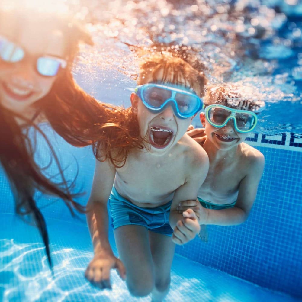 Family swimming in the sparkling swimming pool at The Gates in Houston, Texas