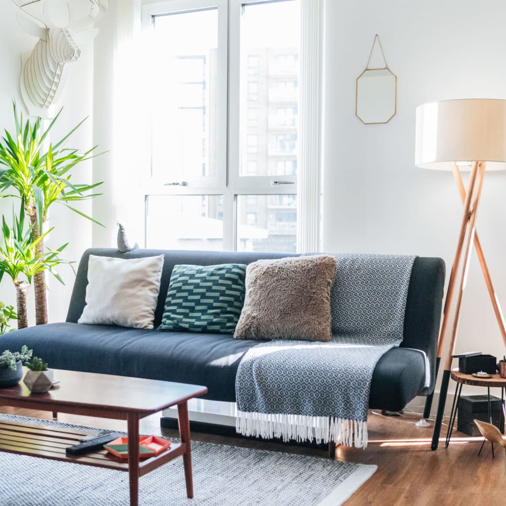 Hardwood-style flooring in the well-furnished living area of an apartment home at Miles One90 in Sachse, Texas