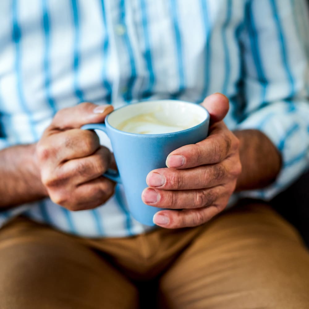 Man holdoing coffee cup  at Vista Prairie at Goldfinch Estates