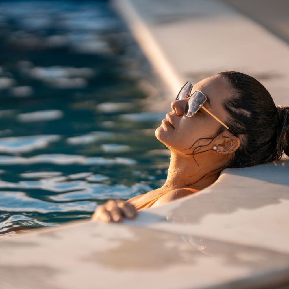 Resident relaxing in swimming pool at The Enclave at Delray Beach in Delray Beach, Florida