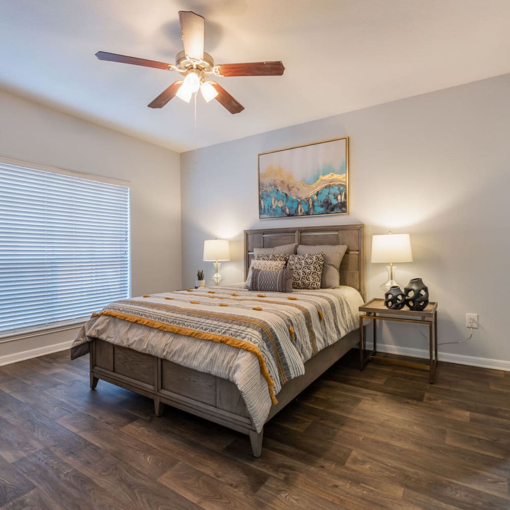 Beautiful bedroom with ceiling fan and wood-style flooring at The Gentry in Houston, Texas