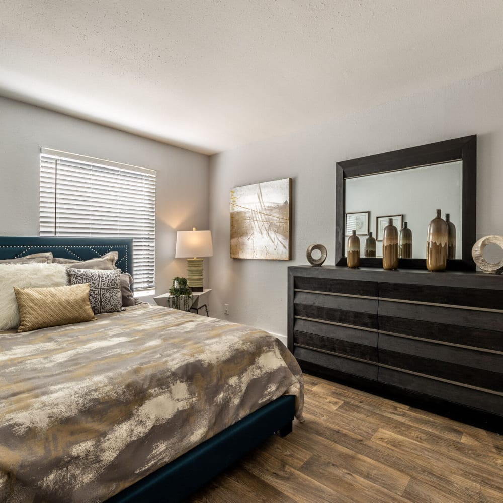 Comfortable bedroom with wood-style flooring at The Grove in Houston, Texas