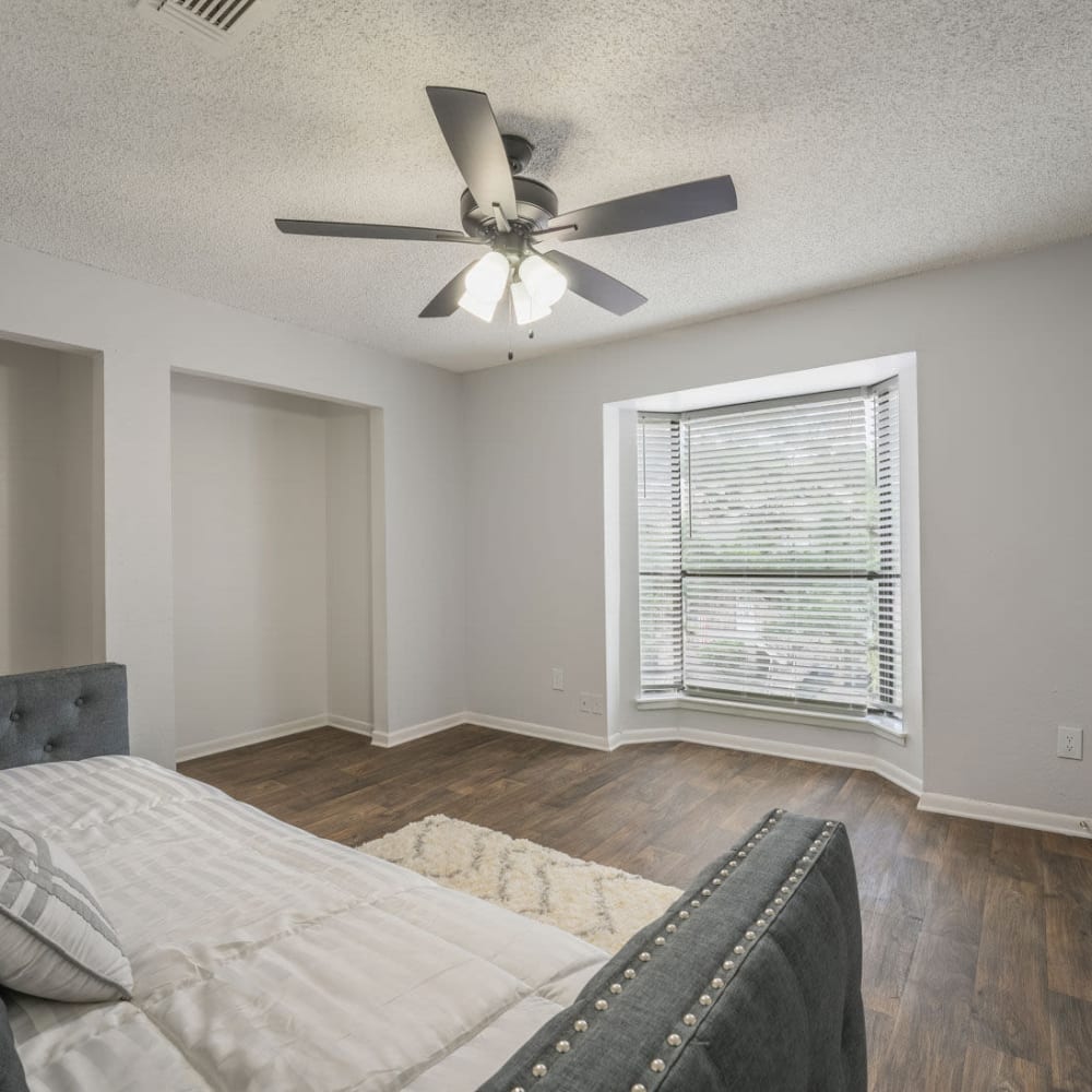 Large bedroom with wood-style flooring and a ceiling fan at Lakebridge Townhomes in Houston, Texas