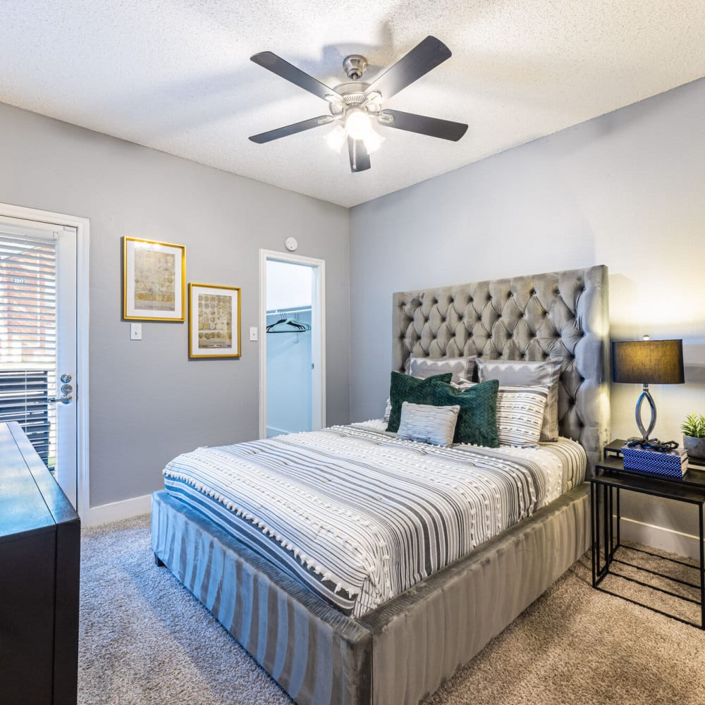 Resident bedroom with ceiling fan and plush carpeting at The Bradford on the Park in Bedford, Texas
