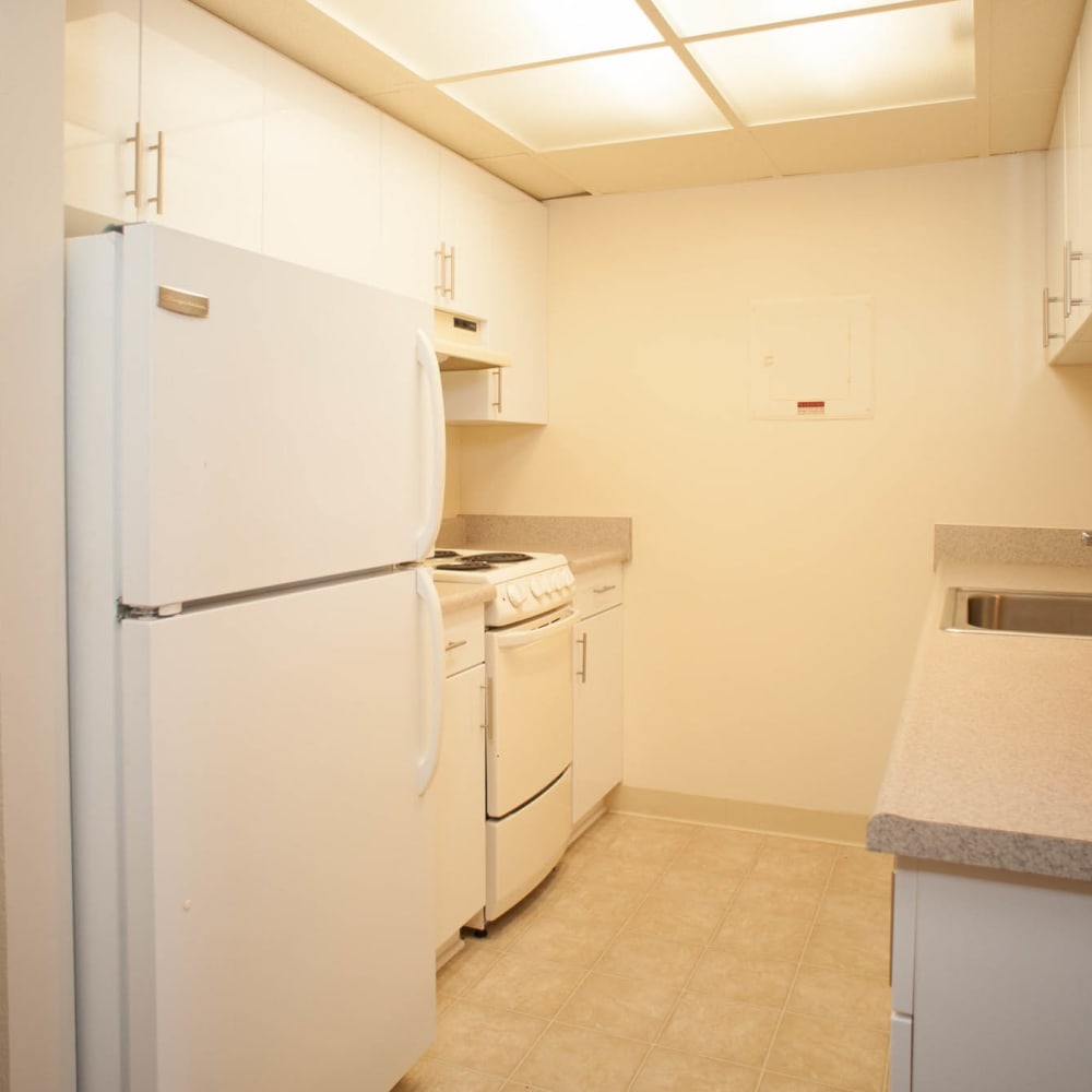 Fully equipped kitchen with white appliances at Miramar Towers in Los Angeles, California