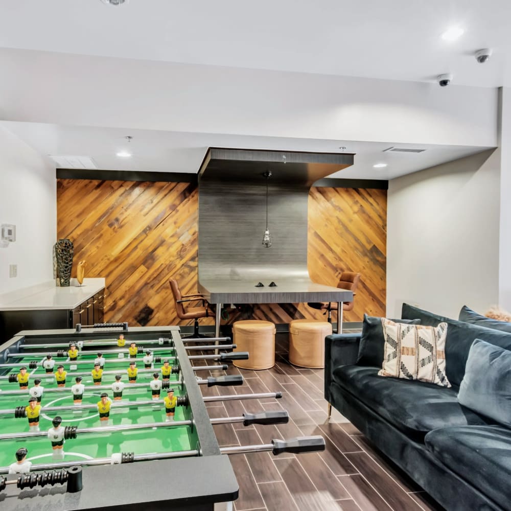 Community game room with foosball table and velvet couch at Bellrock Bishop Arts in Dallas, Texas