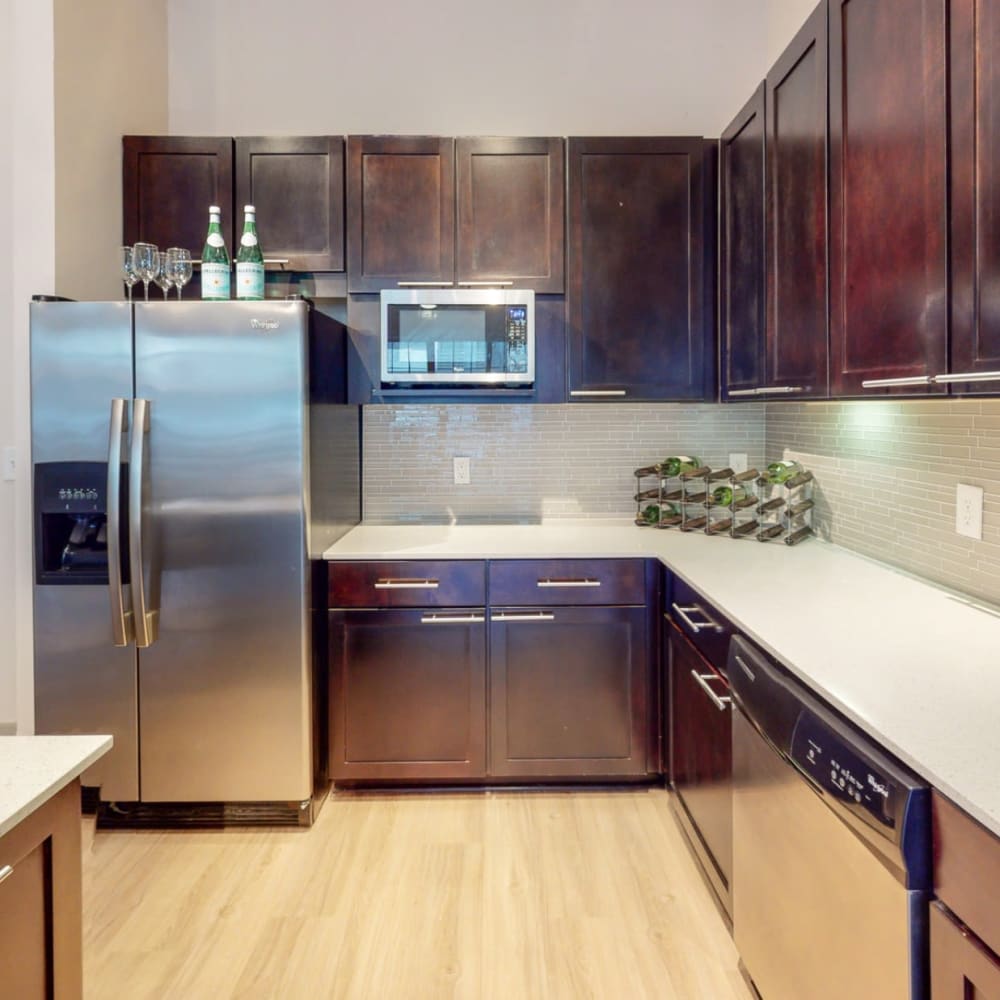 Apartment kitchen with stainless steel fridge and microwave at Bellrock Bishop Arts in Dallas, Texas